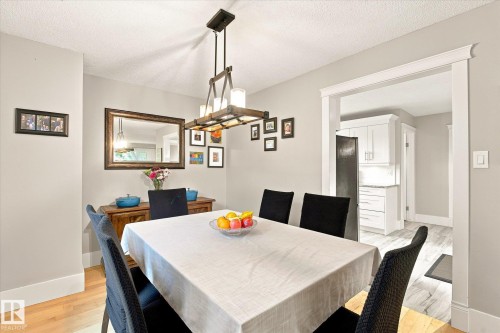 Dining area featuring hardwood flooring, a contemporary chandelier, and a wide cased opening - 3 Akins Drive, St. Albert, AB 