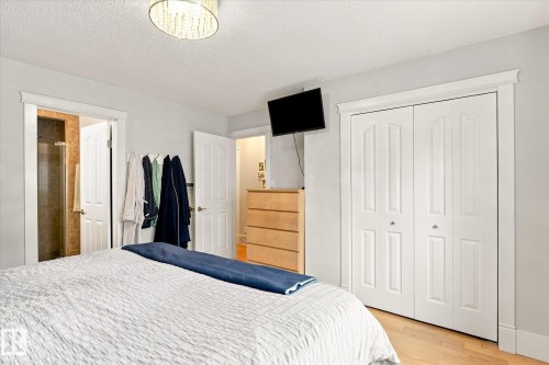 Recessed lighting, wood-finish flooring, white paneled bifold closet doors, and a glass-enclosed shower - 3 Akins Drive, St. Albert, AB 