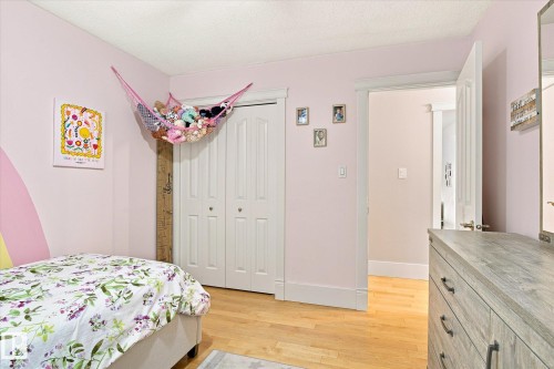 Wood-finish flooring with white trim, double bi-fold closet doors, and painted walls - 3 Akins Drive, St. Albert, AB 
