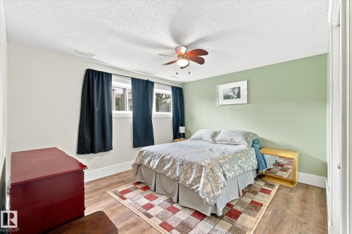 Wood-finish flooring, ceiling fan with integrated lighting, multiple windows, and a closet with a white paneled door - 3 Akins Drive, St. Albert, AB 