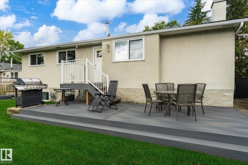 Expansive tiered composite deck with white railings, leading to a stucco exterior with multiple windows - 3 Akins Drive, St. Albert, AB 