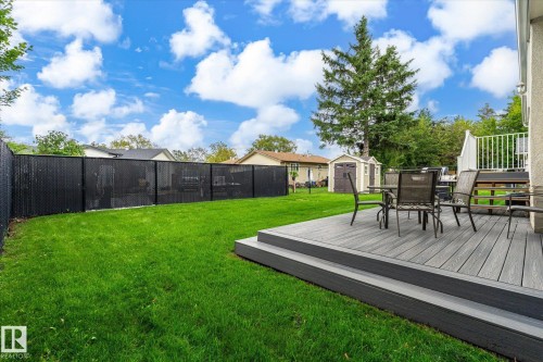 Expansive backyard featuring a manicured lawn, a multi-tiered composite deck, and a privacy fence - 3 Akins Drive, St. Albert, AB 