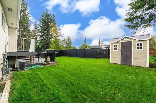 Expansive green lawn with a private deck, white railing, and a storage shed - 3 Akins Drive, St. Albert, AB 