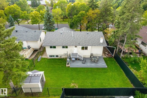 Expansive backyard featuring a manicured lawn, composite decking, and a fire pit area - 3 Akins Drive, St. Albert, AB 