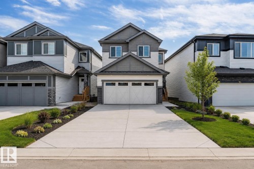 Modern two-story residence with a concrete driveway, attached two-car garage, and a manicured lawn - 91 Dansereau Way, Beaumont, AB 