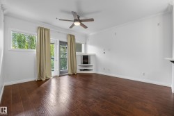 Wood-finish flooring, ceiling fan with integrated lighting, glass-paned door, built-in fireplace with white mantel, and crown molding - 