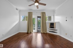 Wood-finish flooring throughout, complemented by crown molding and a ceiling fan with integrated lighting - 