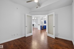 Wood-finish flooring, white walls, and a ceiling fan - 