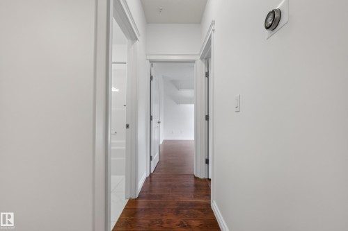 Hardwood-style flooring throughout, white interior doors, and a white wall finish - #210 10121 80 Av Nw, Edmonton, AB 
