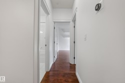 Hardwood-style flooring throughout, white interior doors, and a white wall finish - 