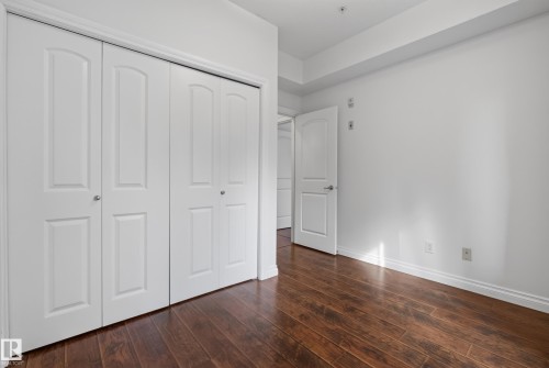 Wood-finish flooring, white walls, and a white interior door - #210 10121 80 Av Nw, Edmonton, AB 