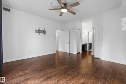 Wood-finish flooring throughout, ceiling fan with integrated lighting, white walls, and white trim - 