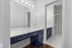 Floating vanity with a quartz countertop, full-width mirror, and chrome vanity lighting - 
