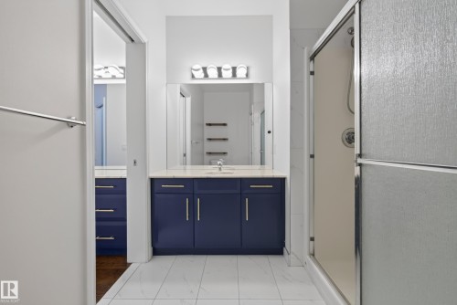 Vanity with blue cabinetry, white countertop, and integrated sink - #210 10121 80 Av Nw, Edmonton, AB 