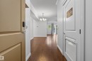 Wood-finish flooring throughout, crown molding details, and a modern chandelier - #210 10121 80 Av Nw, Edmonton, AB 