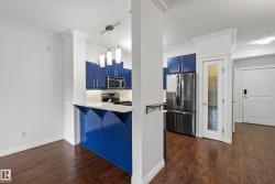 Kitchen featuring blue cabinetry, stainless steel appliances, a white countertop, and pendant lighting - 