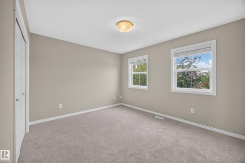 Plush carpeted flooring, two windows, neutral wall tones, and a flush mount ceiling light fixture - 483 Watt Boulevard Sw, Edmonton, AB 