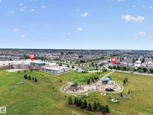 Expansive green space featuring a playground, manicured lawn, and mature trees - 483 Watt Boulevard Sw, Edmonton, AB 