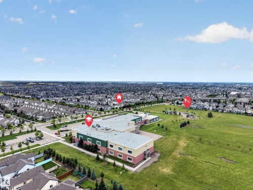 Expansive aerial perspective showcasing a substantial community with abundant green spaces and a large institutional building - 483 Watt Boulevard Sw, Edmonton, AB 