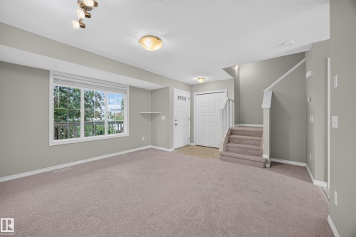 Expansive carpeted living area with a large window - 483 Watt Boulevard Sw, Edmonton, AB 