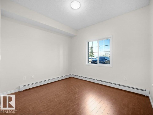Hardwood-finish flooring, white trim, and a window with a grid pattern - #116 16807 100 Av Nw, Edmonton, AB 