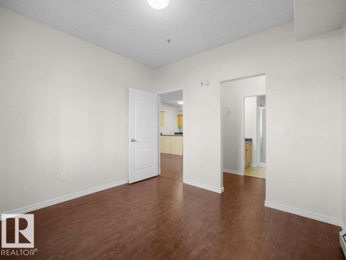 Wood-finish flooring, white walls, and a ceiling-mounted light fixture - #116 16807 100 Av Nw, Edmonton, AB 
