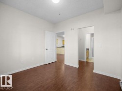 Wood-finish flooring, white walls, and a ceiling-mounted light fixture - 