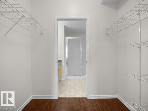Walk-in closet with dark wood-finish flooring - #116 16807 100 Av Nw, Edmonton, AB 