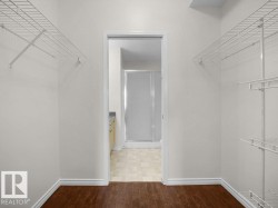 Walk-in closet with dark wood-finish flooring - 
