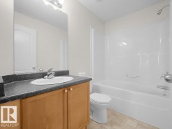 Vanity with wood-finish cabinetry, integrated sink, and gray countertop - 