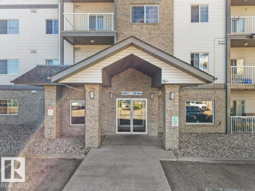 Brick veneer exterior with siding accents, covered entryway, and glass-paneled double doors - #116 16807 100 Av Nw, Edmonton, AB 