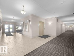 Entryway with porcelain tile flooring, an elevator, pendant lighting, and wall sconces - 