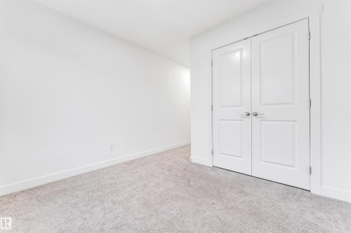 Neutral tone walls, light-colored carpeting, and white panel doors with brushed nickel hardware - #45 2710 66 St Sw, Edmonton, AB 