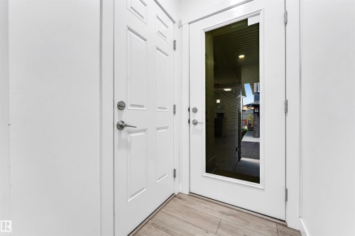 White paneled entry door with satin nickel hardware - #45 2710 66 St Sw, Edmonton, AB 