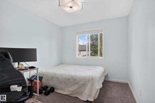 Square flush-mount ceiling light fixture, white window frame, textured ceiling, and gray carpeted flooring - 17363 120 Street Nw, Edmonton, AB 