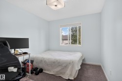 Square flush-mount ceiling light fixture, white window frame, textured ceiling, and gray carpeted flooring - 