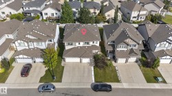 Two-story property with a dual-car garage, concrete driveway, and landscaped front yard - 
