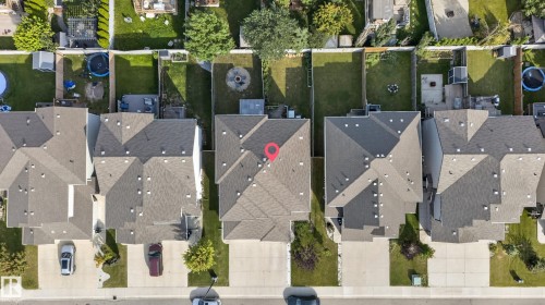 Attached single-family home featuring a pitched roofline, paved driveway, and a private backyard with a green lawn - 17363 120 Street Nw, Edmonton, AB 