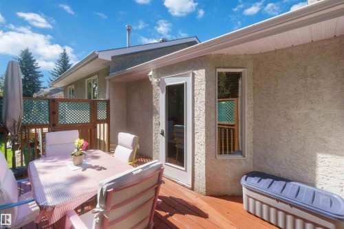 Exterior stucco finish, wood deck, white frame glass door, vertical window, and lattice privacy screen - #6 15 Poirier Av, St. Albert, AB 