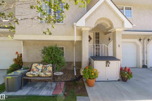 Stucco exterior with a covered entry, concrete driveway, and attached garage - #6 15 Poirier Av, St. Albert, AB 