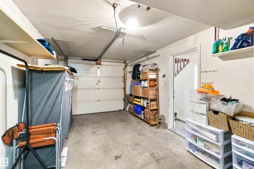 Attached garage with concrete flooring, overhead lighting, and built-in shelving - #6 15 Poirier Av, St. Albert, AB 