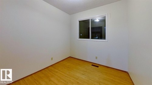 Wood-finish flooring with white walls and a large window - 4611 52 Avenue, Stony Plain, AB 