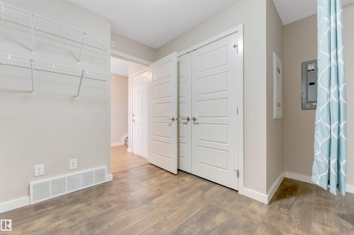 Wood-finish flooring, crisp white trim, and ample closet storage with bi-fold doors - 3340 15A Avenue Nw, Edmonton, AB 