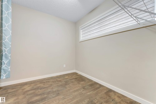 Light-toned walls with wood-finish flooring - 3340 15A Avenue Nw, Edmonton, AB 