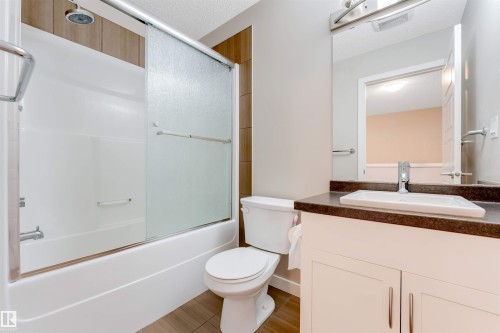 Bathroom featuring a white vanity with under-sink cabinetry, a surface-mounted sink, and a dark countertop - 3340 15A Avenue Nw, Edmonton, AB 