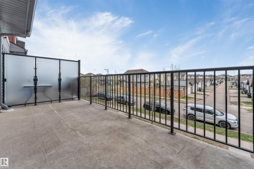 Concrete balcony with black metal railings and privacy screens - 3340 15A Avenue Nw, Edmonton, AB 