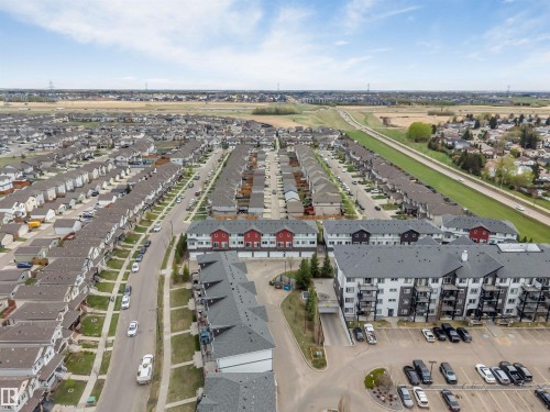 Aerial perspective showcasing a residential community with multi-story apartment buildings, townhomes, and single-family residences - 3340 15A Avenue Nw, Edmonton, AB 