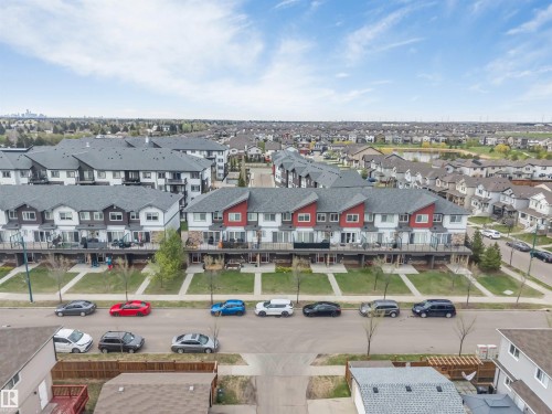 Terraced townhomes featuring balconies, stone facades, and individual entrances - 3340 15A Avenue Nw, Edmonton, AB 
