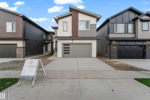 Modern exterior with multi-tone siding, a prominent attached garage, and a concrete driveway - 236 Linden Loop, Leduc, AB 