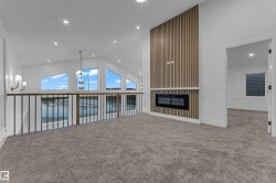 Vaulted ceiling with recessed lighting, linear electric fireplace, wood slat accent wall, and trapezoidal windows - 